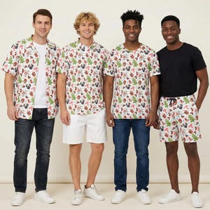 May include: A collection of clothing featuring a white base with a repeating pattern of green Christmas trees, red ornaments, and pug dog faces. The set includes a short-sleeved button-down shirt, a crew-neck t-shirt, and a pair of drawstring shorts.