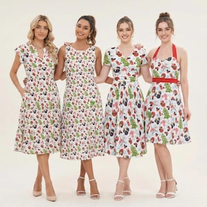 May include: Four knee-length dresses featuring a white base with a repeating Christmas-themed print of green trees, red ornaments, and festive icons. The dresses include various necklines, sleeve lengths, and a red-accented halter style.