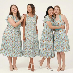 May include: Four dresses in a light blue fabric featuring a colourful repeating pattern of various cartoon characters. The dresses include a flutter-sleeve midi dress, a sleeveless midi dress, a short-sleeve midi dress, and a halter-neck dress.
