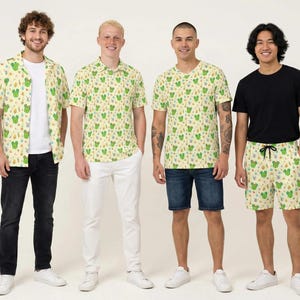 May include: Four garments featuring a light yellow background with a repeating pattern of green cacti, yellow flowers, and small brown shapes. The collection includes a short-sleeved button-down shirt, a t-shirt, and a pair of drawstring shorts.