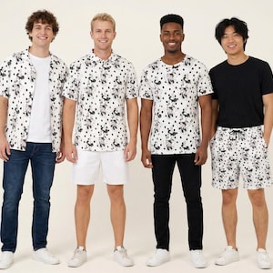 May include: A collection of clothing featuring a white and black polka dot pattern with Mickey Mouse silhouettes. The set includes a short-sleeve button-down shirt, a polo shirt, a crew-neck t-shirt, and drawstring shorts, paired with jeans and trousers.