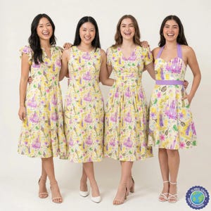 May include: Four women in dresses with a yellow backdrop, featuring a repeating pattern of purple castles and fairytale motifs. The dresses vary in style, including a halter neck and a wrap design. The dresses are knee-length.