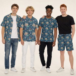 May include: A collection of clothing featuring a dark blue fabric with a repeating pattern of mermaids, seahorses, crabs, and coral. The items include a button-up shirt, a polo shirt, a short-sleeve t-shirt, and pocket beach shorts.