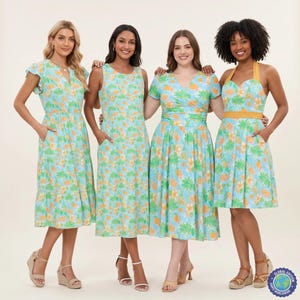 May include: Four dresses featuring a light blue background with a repeating pattern of orange citrus fruits and green leafy branches. The dresses vary in style, including flutter sleeves, sleeveless cuts, short sleeves with a wrap bodice, and a halter neck.