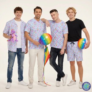 May include: Four individuals wearing light blue shirts and shorts featuring a repeating pattern of unicorns and rainbows. One person holds a purple dragon plush, another a rainbow beach ball, and another a rainbow kite. One wears a black t-shirt.