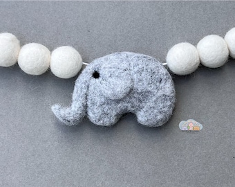 May include: A gray felt elephant garland with white felt balls strung on a white string.