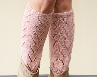 May include: A pair of pink knitted knee-high socks with a lacy pattern. The socks are worn with brown ankle boots.