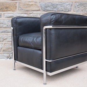 May include: A black leather armchair with a chrome frame. The chair has a simple, modern design.
