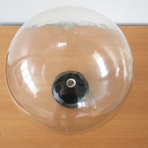 May include: A clear glass globe lampshade with a black ceramic socket and a visible electrical cord.