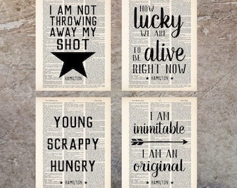 Può includere: Quattro citazioni stampabili dal musical Hamilton. Le citazioni sono "Non sto buttando via il mio colpo", "Che fortuna che abbiamo di essere vivi adesso", "Giovane, grintoso, affamato", e "Sono inimitabile, sono un originale".