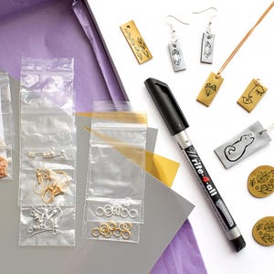 Puede incluir: Un kit de manualidades para hacer joyas con dijes de metal dorado y plateado, cadenas, anillos de salto, ganchos para pendientes y un marcador permanente negro etiquetado como "Rite-A-All".