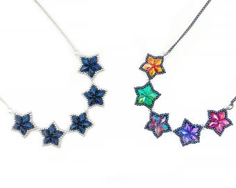 May include: Two beaded necklaces with star-shaped pendants. One necklace has blue star-shaped pendants, and the other has rainbow-colored star-shaped pendants.