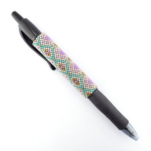 Puede incluir: Un bolígrafo negro con un cañón de cuentas que presenta un patrón geométrico en tonos de morado, verde azulado y dorado.