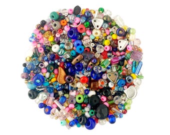 May include: A vibrant assortment of colorful beads in various shapes and sizes. The mix includes round, triangular, and rectangular beads in shades of blue, pink, green, yellow, and more. Ideal for jewelry making and crafting.