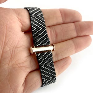 May include: A black and silver beaded bracelet with a silver toggle clasp.