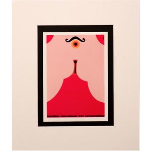 May include: Abstract art print with a red and pink design, framed by a black border. The artwork includes a stylized eye, mustache, and a red shape resembling a dress or curtain. The print is mounted on a white background.