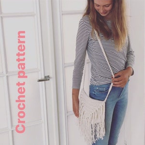 May include: A white crocheted bag with fringe hanging from the bottom. The bag is worn as a crossbody bag.