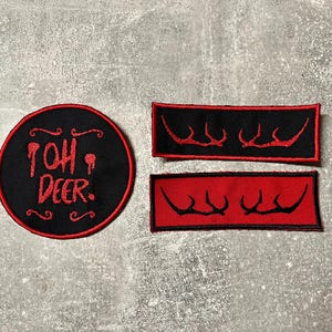 Könnte beinhalten: Ein Set aus schwarz-roten gestickten Aufnähern. Ein runder Aufnäher zeigt den Text "TOH DEER." in Rot. Zwei rechteckige Aufnäher haben ein schwarzes Design auf rotem Hintergrund. Die Aufnäher sind wahrscheinlich für Kleidung oder Accessoires.