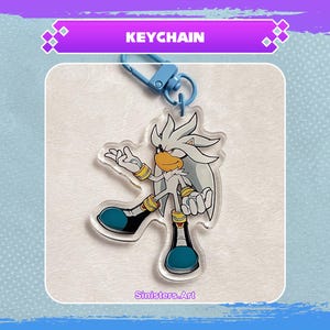 Könnte beinhalten: Ein klarer Acryl-Schlüsselanhänger mit einer Cartoonfigur mit silbernem Fell, gelben Akzenten und blauen Schuhen. Der Schlüsselanhänger hat einen blauen Verschluss und das Wort "KEYCHAIN" in einem lila Banner. Der Künstlername "Sinisters.Art" ist aufgedruckt.