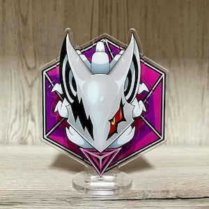 May include: A clear acrylic stand featuring a white and black character design with a red eye, set against a pink and purple hexagonal background. The stand has a clear base with a triangular design.