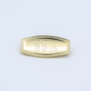 May include: Gold-toned metal monogram pin with a raised border and the initials "SCM" engraved inside.