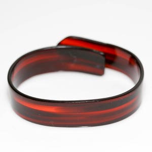 May include: A brown and red plastic headband with a striped design.