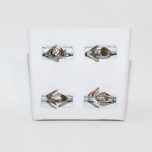 May include: Four silver rings with arrowhead designs displayed on a white background.