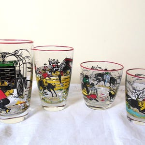 May include: Set of four vintage clear drinking glasses with red rims, featuring colorful cowboy and western-themed illustrations. The glasses depict scenes of cowboys, horses, and wagons, adding a touch of retro charm to any collection.