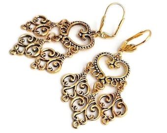 May include: Gold filigree dangle earrings with a heart-shaped design. The earrings have a hook closure.