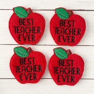 May include: Four red felt apple-shaped patches with black embroidery that reads "Best Teacher Ever".