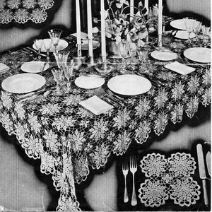 Puede incluir: Imagen en blanco y negro de una mesa decorada con un mantel de encaje de ganchillo y manteles individuales a juego. La mesa está puesta con platos, cubiertos y cristalería. En el centro hay velas altas y un arreglo floral. El texto "Queen Anne Lace" es visible.