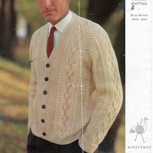 May include: Cream-colored cable-knit cardigan with dark brown buttons. The image shows a man wearing the sweater over a white shirt and red tie. The text on the right side of the image reads "Emu Double Knitting" and "36 to 44 inch chest sizes."
