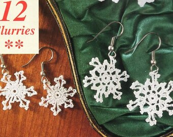 May include: A pair of snowflake earrings with silver hooks. The snowflakes are white and crocheted. The earrings are displayed on a green velvet background with a pearl necklace.