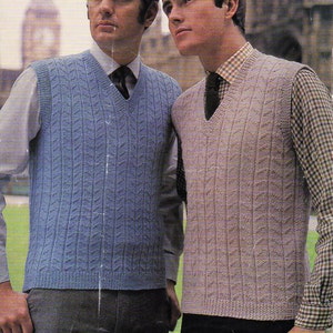 Op de afbeelding: Twee mannen dragen gebreide vesten. Het vest aan de linkerkant is blauw en het vest aan de rechterkant is beige. Beide vesten hebben een kabelbreipatroon. De tekst op de afbeelding luidt "Wendy Double Knit or 4 Ply... 40/44" Chest 9p 737"