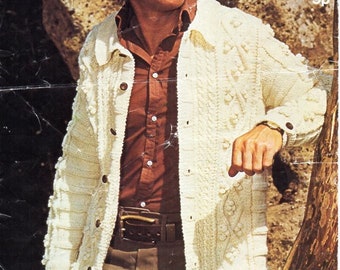 Pode incluir: Cardigã creme com botões e padrões de malha texturizada. A peça de roupa vintage apresenta gola e mangas compridas. A imagem também mostra uma camisa marrom abotoada, calças marrons e um cinto de couro marrom. A palavra "SIDAR" está no topo.