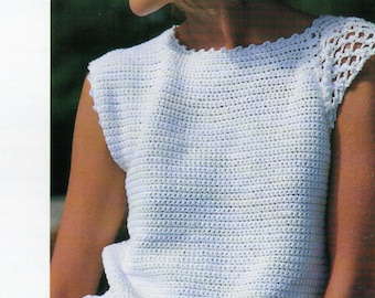 Peut inclure: Un haut blanc en crochet avec un col rond et des manches courtes. Les manches ont une bordure en dentelle. Le mannequin porte une jupe rose. Le fil est Patons Cotton Perle.