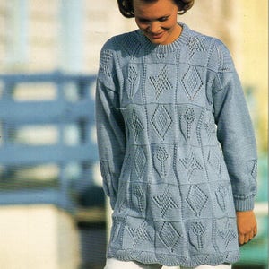 May include: A light blue knitted sweater with a geometric pattern. The sweater has a round neckline and long sleeves.