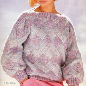 May include: A light pink, blue, and white knitted sweater with a geometric pattern. The sweater has a boat neck and long sleeves. The model is wearing a pink skirt.