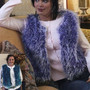 Puede incluir: Un chaleco de color morado y blanco con un suéter rosa debajo. El chaleco está abierto en la parte delantera y tiene un estilo largo y fluido.