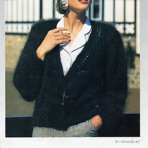 Pode incluir: Um casaco de mohair preto com uma camisa branca de colarinho por baixo. O casaco tem uma textura felpuda e é usado por uma mulher com cabelo escuro e óculos de sol. A imagem é de um livro de padrões de tricô.