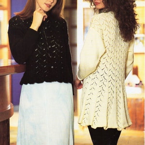 Könnte beinhalten: Zwei Frauen präsentieren Strickjacken. Die Frau links trägt eine schwarze Strickjacke mit einem gewellten Saum und die Frau rechts trägt eine weiße Strickjacke mit einem Spitzenmuster. Der Text "Jarol" befindet sich in der oberen linken Ecke des Bildes. Der Text "E1059 DK 30 - 52 in 76 - 132 cm" befindet sich in der oberen rechten Ecke des Bildes.