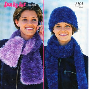 May include: Two women wearing matching blue and purple fuzzy scarves and hats. The hat is a slouchy beanie style. The scarves are long and wide. The text "8305 Hat and Scarves one size" is in the top right corner of the image.