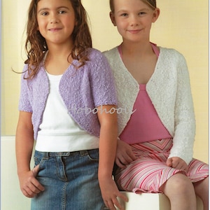 May include: Two girls wearing knitted cardigans. The girl on the left is wearing a lavender cardigan and a denim skirt. The girl on the right is wearing a white cardigan and a pink and white striped skirt.