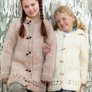 May include: Two girls wearing knitted cardigans. The girl on the left is wearing a light brown cardigan with brown buttons. The girl on the right is wearing a white cardigan with brown buttons.