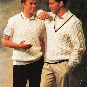 May include: Two men wearing white cable knit sweaters with contrasting trim. One sweater has a V-neck and the other has a crew neck.