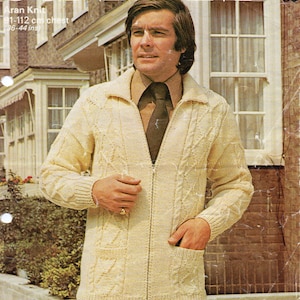 Puede incluir: Un cárdigan de punto Aran de color crema con cierre de cremallera y una corbata marrón. El cárdigan tiene un patrón de punto de cable y dos bolsillos. El texto "Aran Knit 91-112 cm chest (36-44 ins)" está impreso en la imagen.