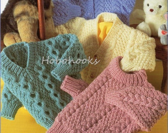 May include: A collection of hand-knitted sweaters in various colors, including blue, yellow, and pink. The sweaters feature textured patterns and button closures, showcasing a cozy, handmade aesthetic. The image includes a plush dog and bear.
