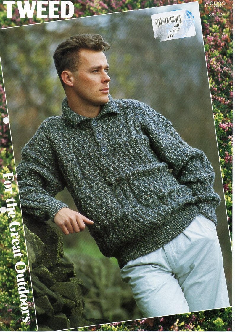 May include: A green tweed sweater with a collared neckline and three buttons. The sweater has a textured knit pattern and a front pocket. The words "For the Great Outdoors" are printed on the left side of the image.