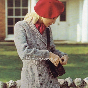 Peut inclure: Un cardigan gris en tricot à double boutonnage et une écharpe rouge. Le cardigan est porté par une personne portant un béret rouge et un sac brun suspendu à l'épaule.