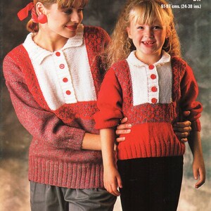 May include: Two people wearing matching red and white knit sweaters. The sweaters have a white panel on the chest with red buttons and a collar. The text "Studley WOOL RICH DK" is at the top of the image. The sweaters are 24-38 inches in length.